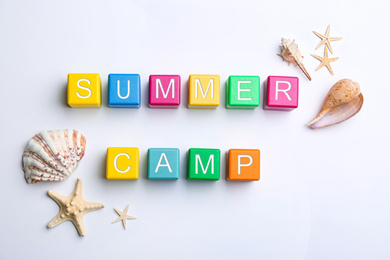 Photo of Colorful wooden cubes with phrase SUMMER CAMP on white background, flat lay