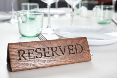 Photo of Table setting with RESERVED sign in restaurant. Space for text