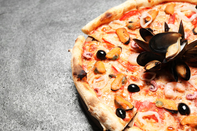 Photo of Tasty fresh pizza with seafood on grey table, closeup