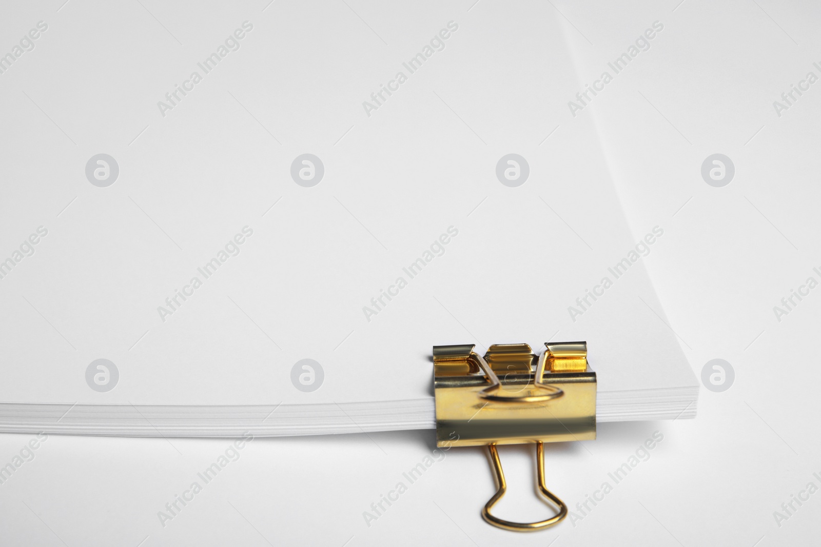 Photo of Sheets of paper with clip on white background, closeup