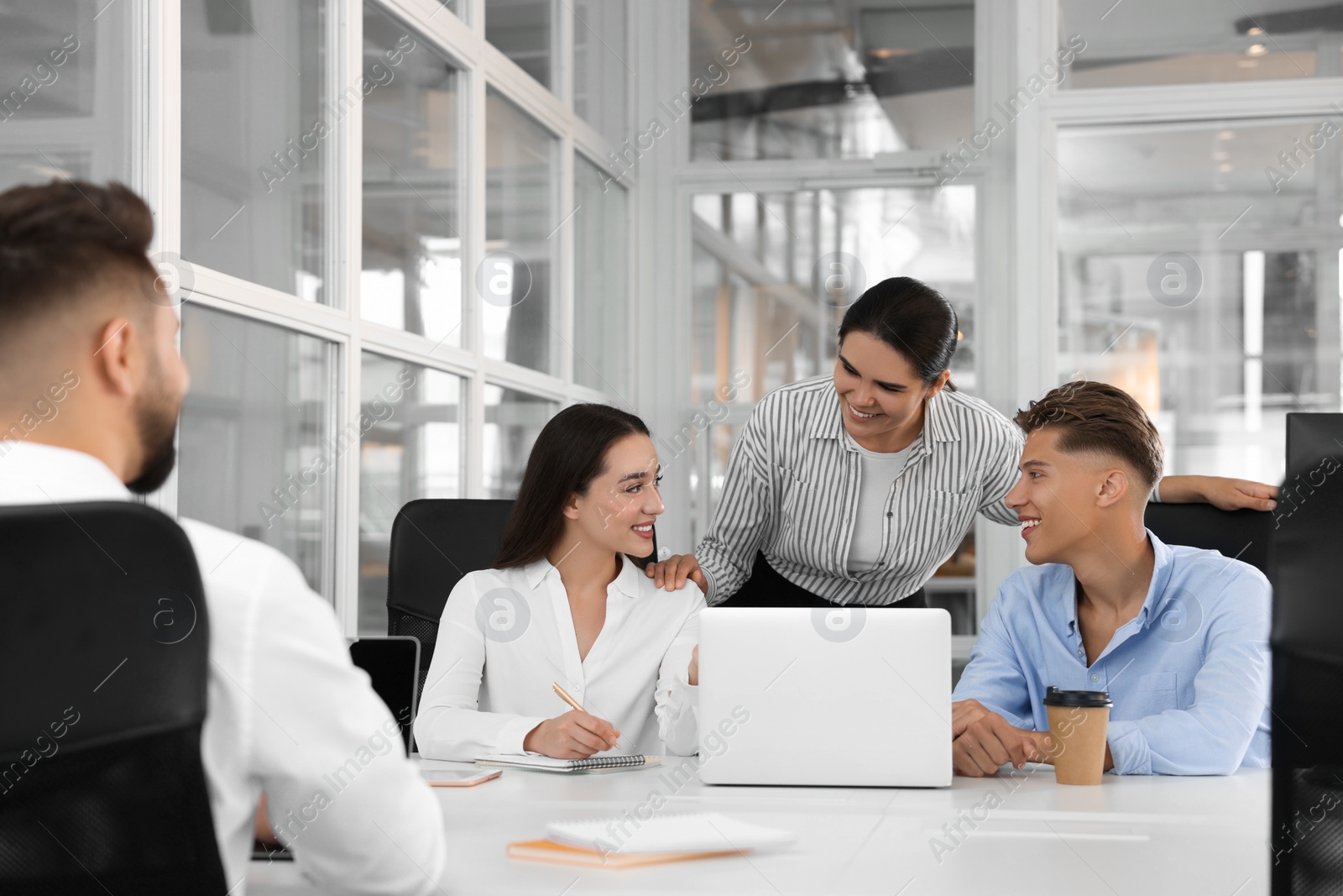 Photo of Colleagues working together in open plan office