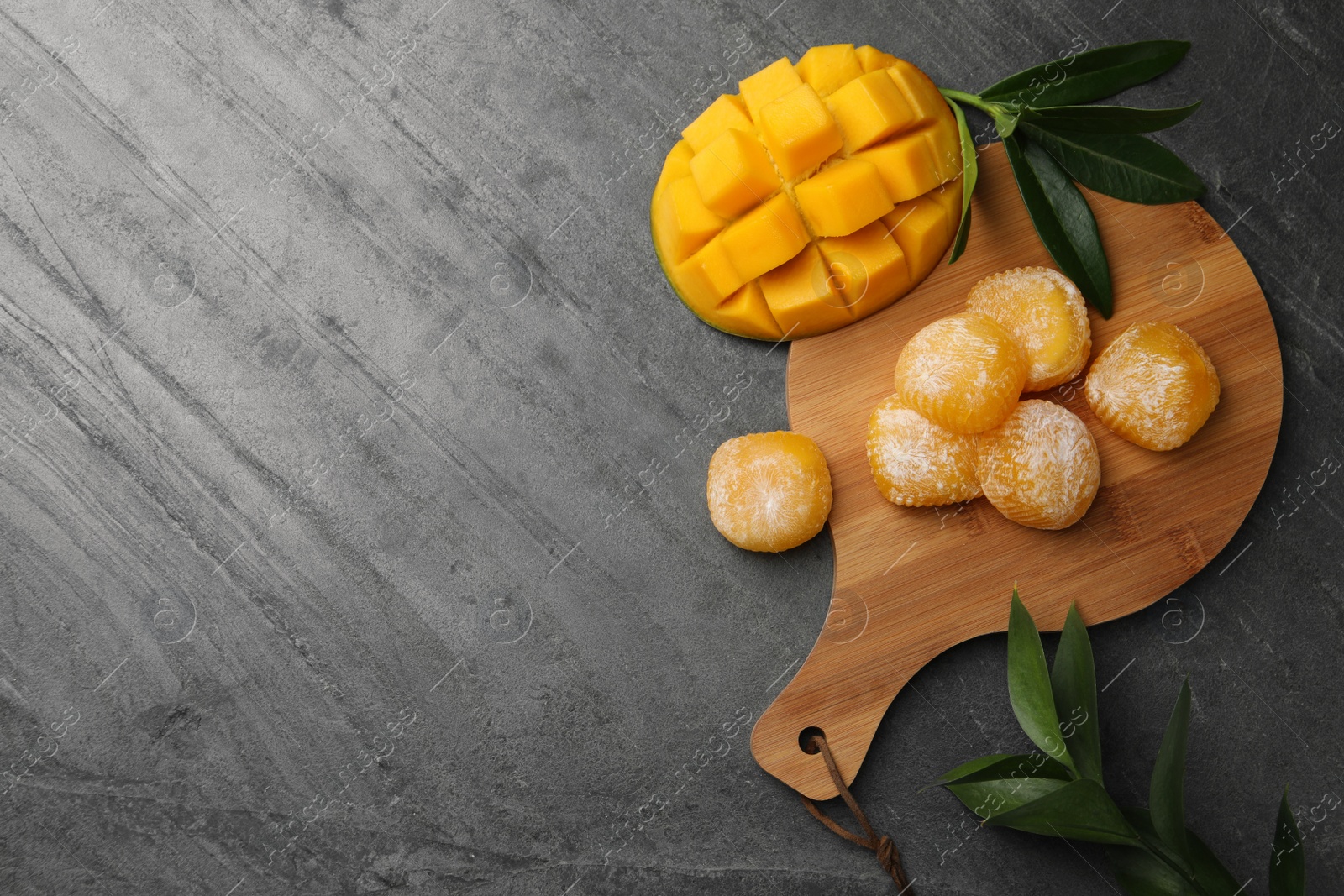 Photo of Delicious mango mochi on grey table, flat lay. Space for text