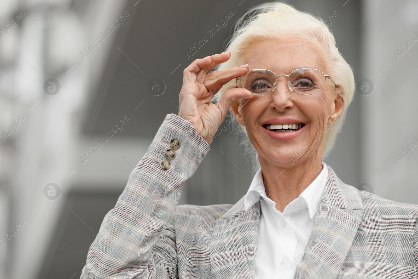 Photo of Portrait of happy mature woman in glasses outdoors