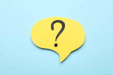 Photo of Paper speech bubble with question mark on light blue background, above view