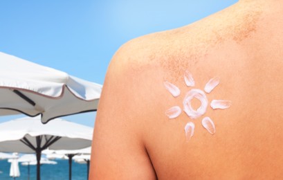 Image of Sun protection. Woman with sunblock on her back on beach, closeup