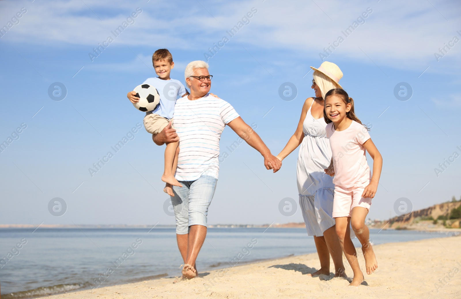 Photo of Cute little children with grandparents spending time together on sea beach