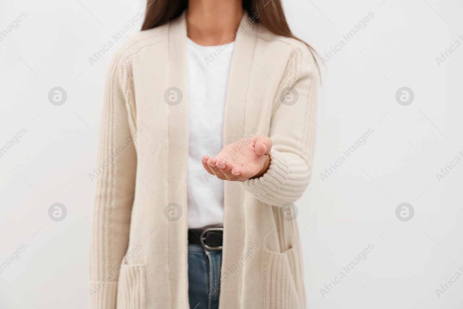 Photo of Woman giving helping hand on light background