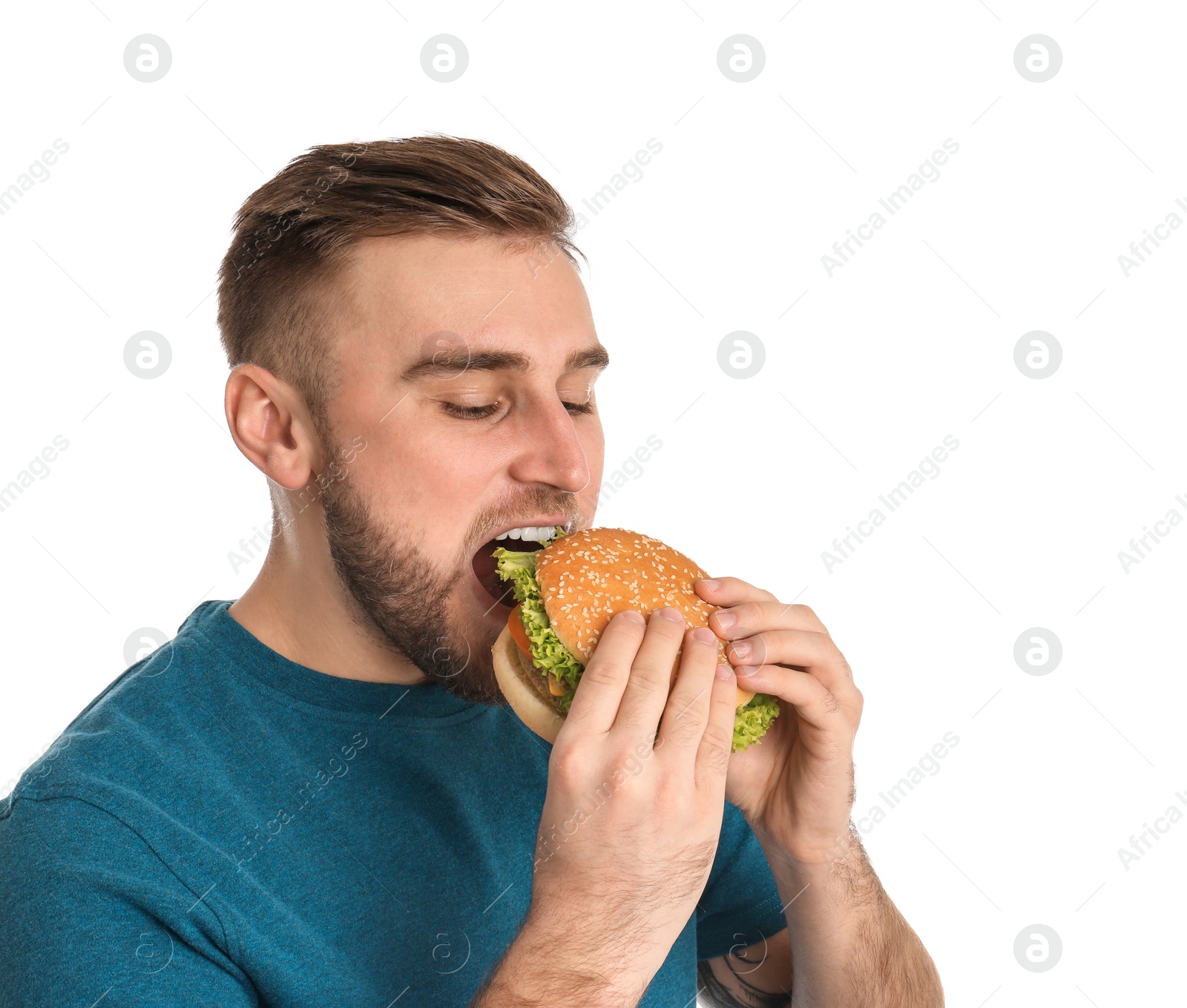 Photo of Young man eating tasty burger on white background