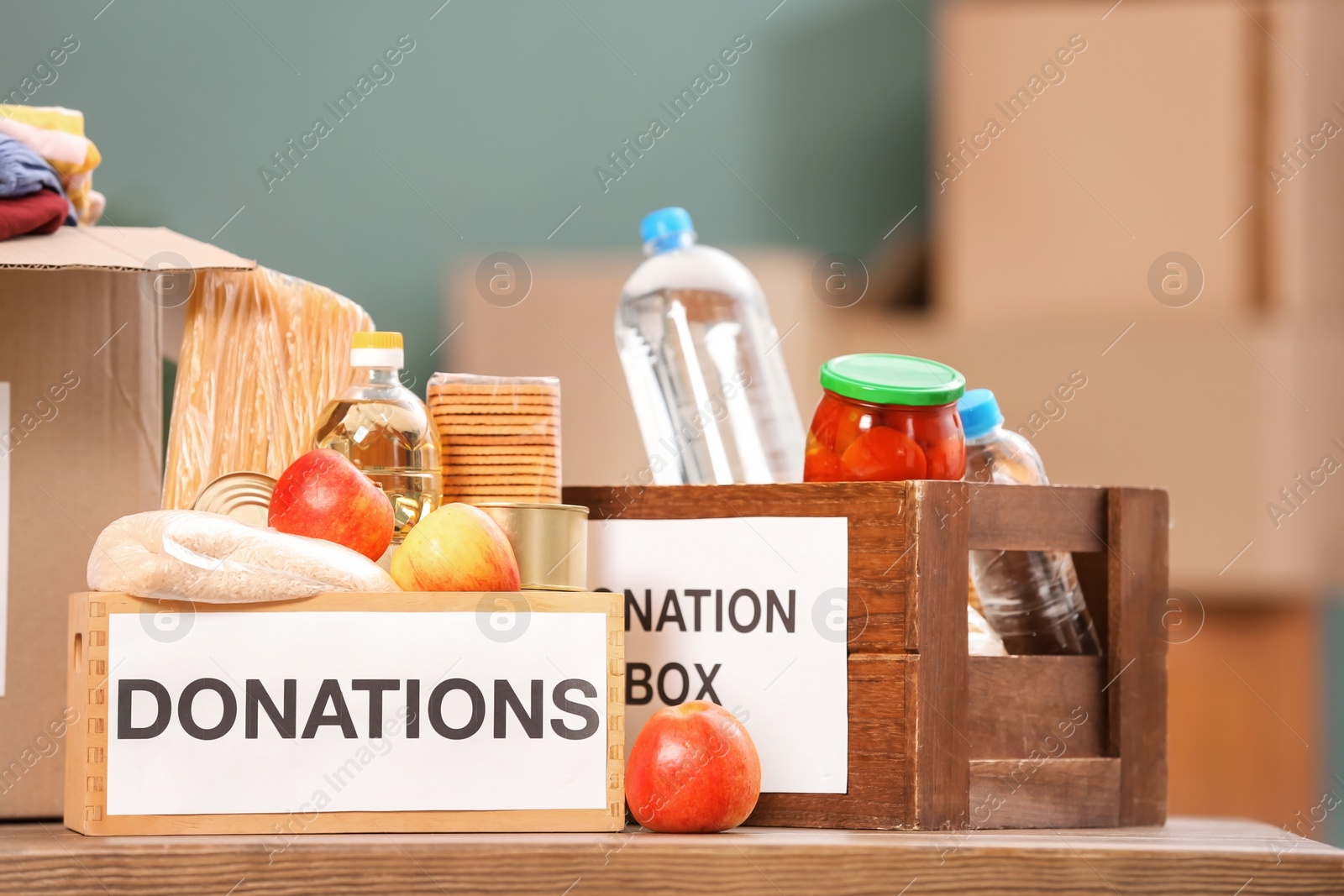 Photo of Donation boxes with food products on table indoors