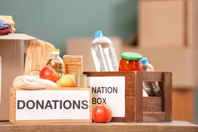 Photo of Donation boxes with food products on table indoors