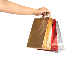 Woman holding paper shopping bags on white background, closeup. Space for design