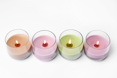 Photo of Color wax candles in glass holders isolated on white