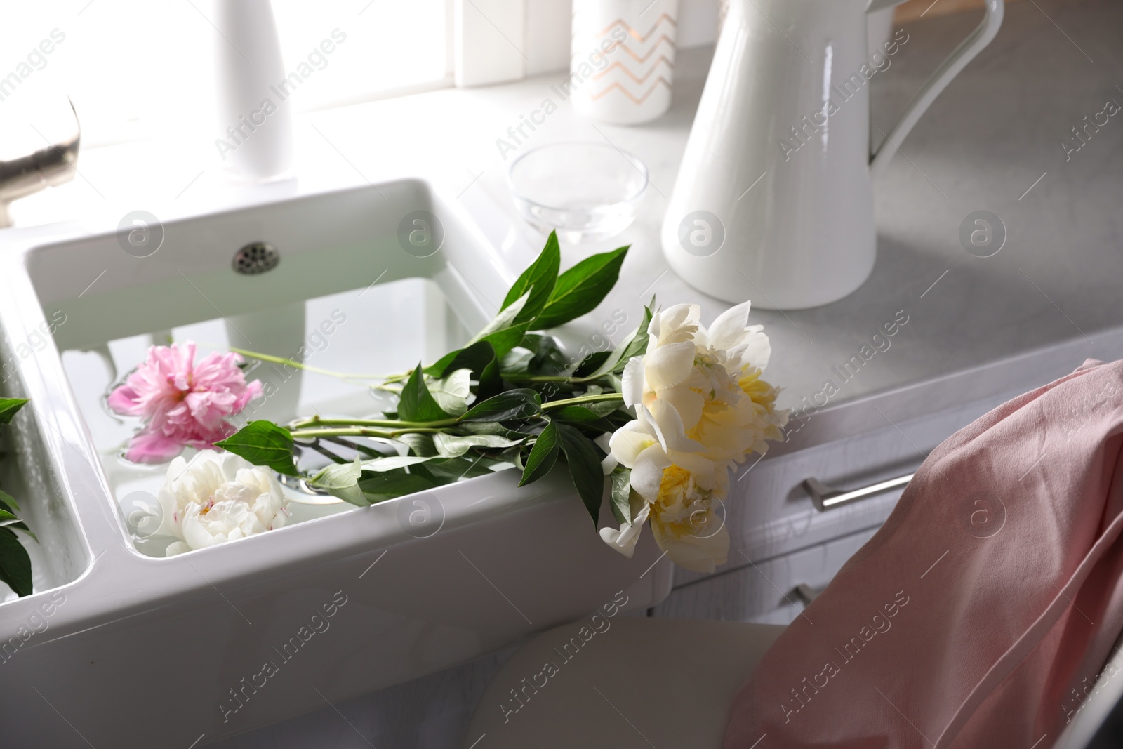 Photo of Bunch of beautiful peonies in kitchen sink