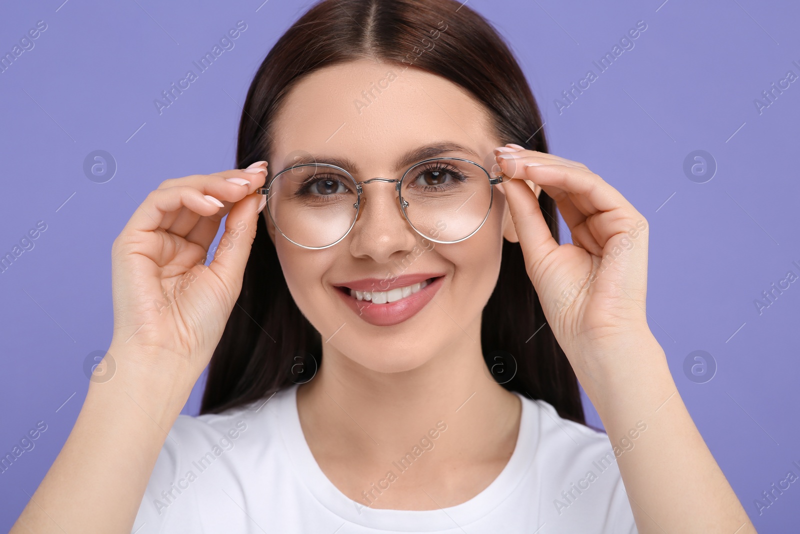 Photo of Portrait of smiling woman in stylish eyeglasses on violet background