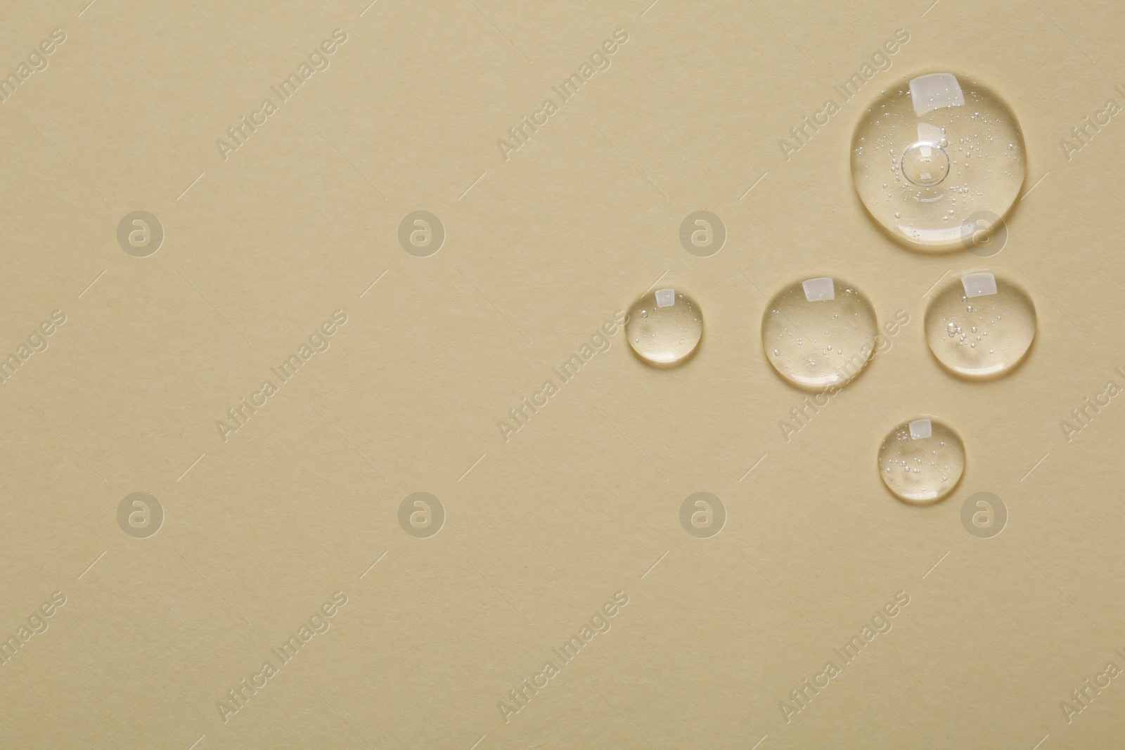 Photo of Samples of cosmetic serum on beige background, flat lay. Space for text