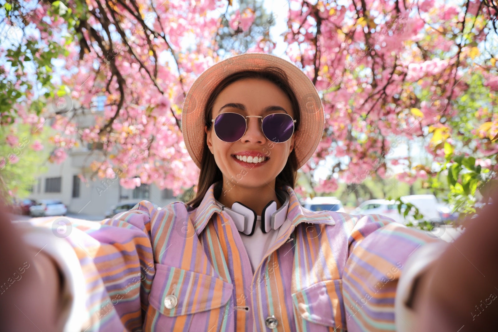 Photo of Happy young woman taking selfie in park