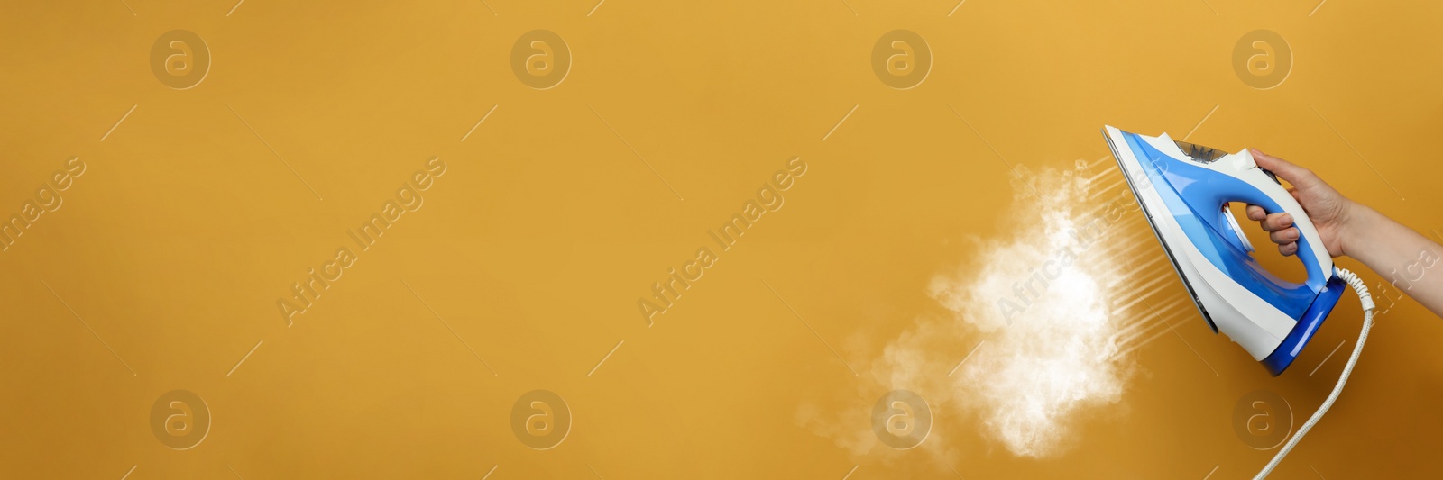 Image of Woman with iron on orange background, closeup. Banner design with space for text