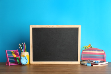 Photo of Small chalkboard and different school stationery on table