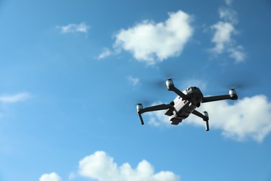 Photo of Modern drone with camera flying in sky on sunny day