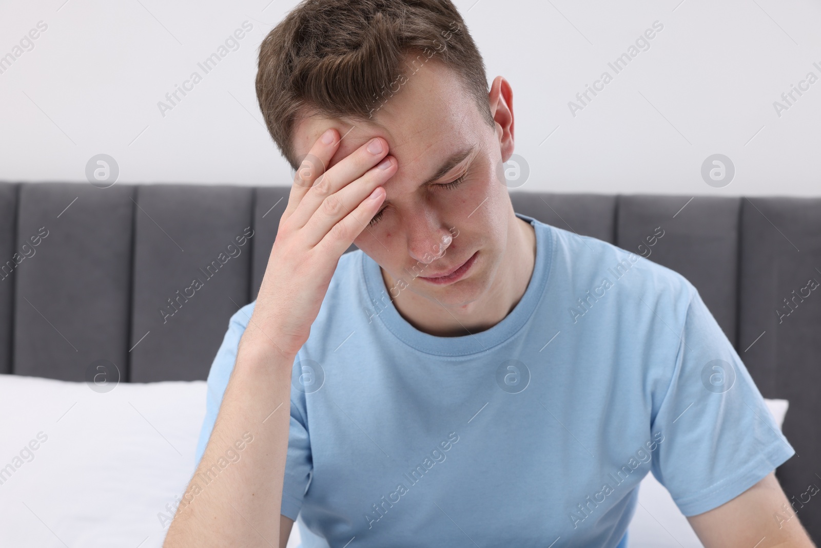 Photo of Sad man suffering from headache at home