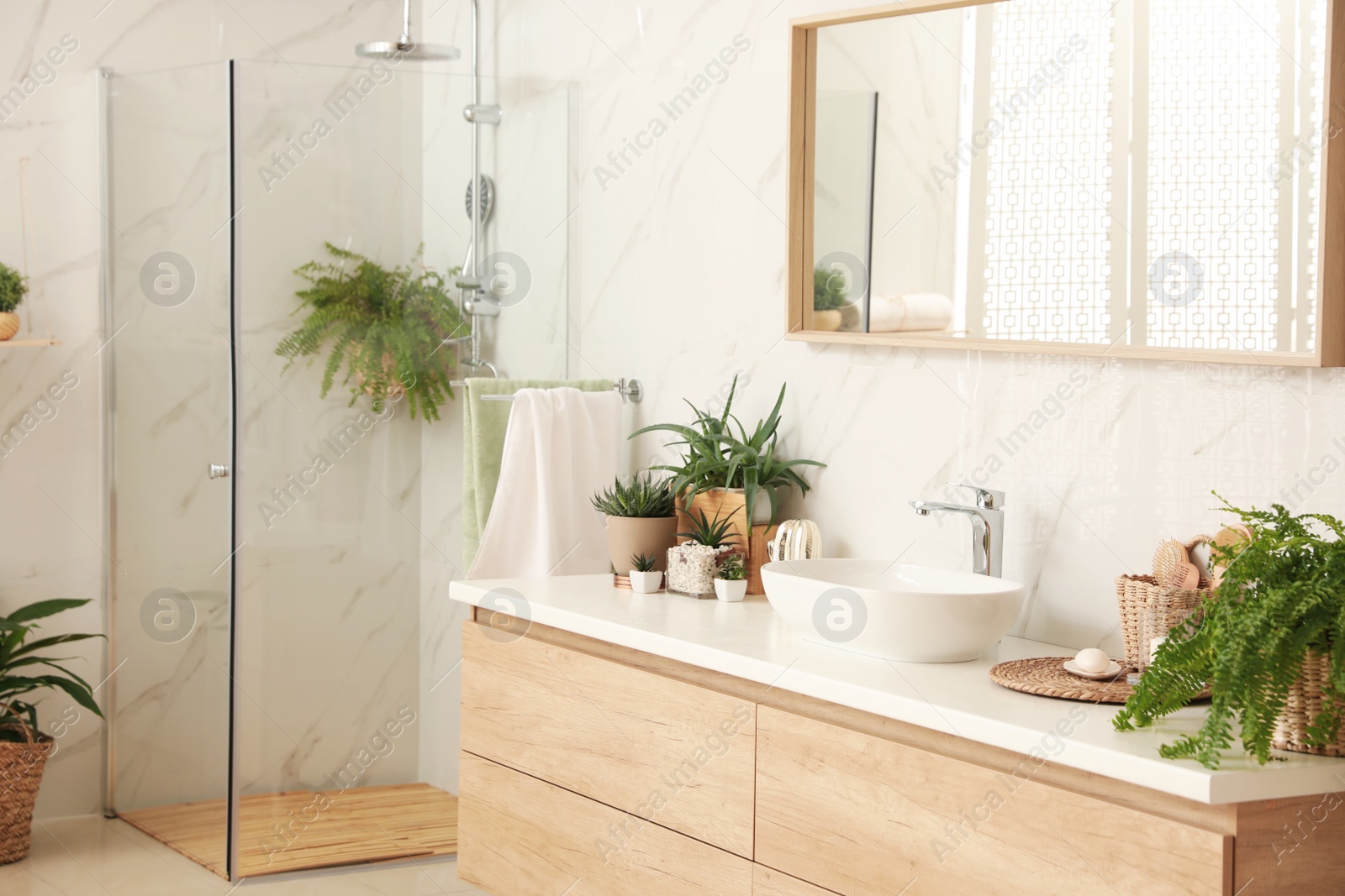 Photo of Stylish bathroom interior with countertop, shower stall and houseplants. Design idea