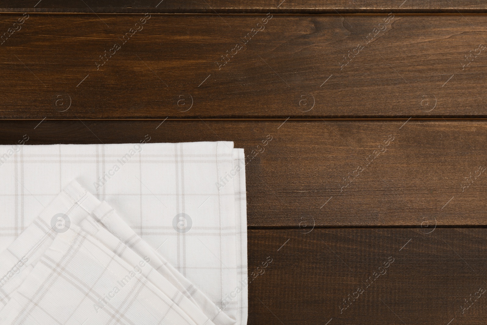 Photo of Kitchen towel on wooden table, top view. Space for text