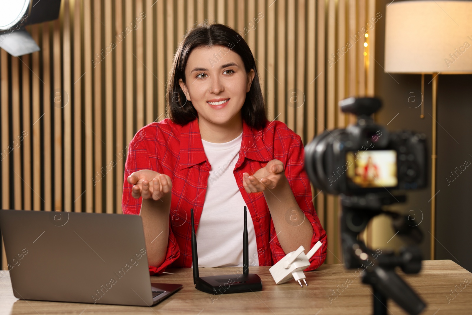 Photo of Smiling technology blogger recording video review about WI-FI devices at home