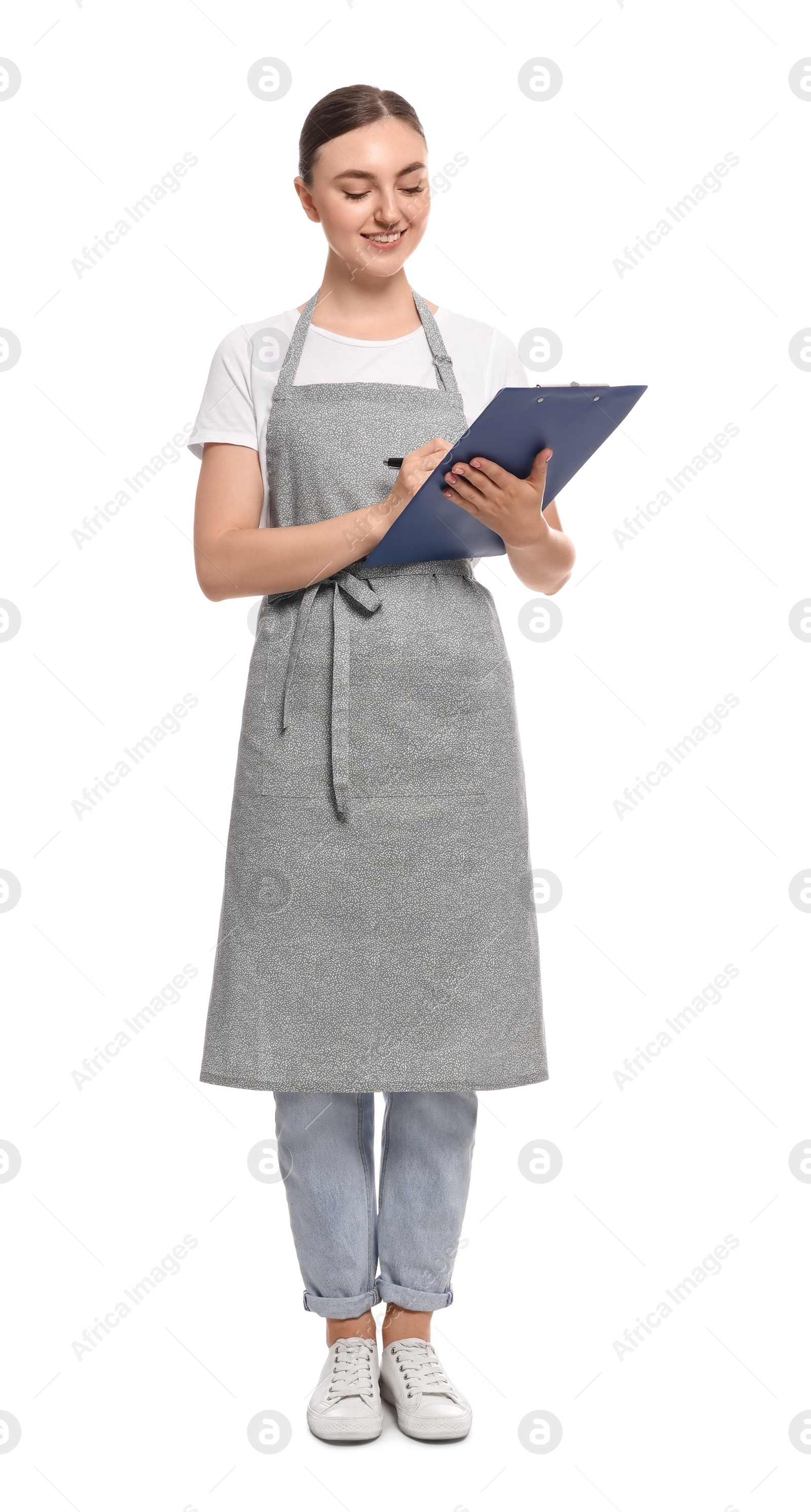 Photo of Beautiful young woman in clean apron with clipboard on white background