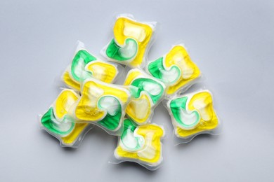 Many dishwasher detergent pods on light grey background, flat lay