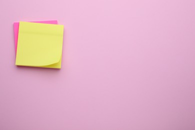 Photo of Paper notes on pale pink background, top view. Space for text