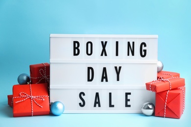 Lightbox with phrase BOXING DAY SALE and Christmas decorations on light blue background