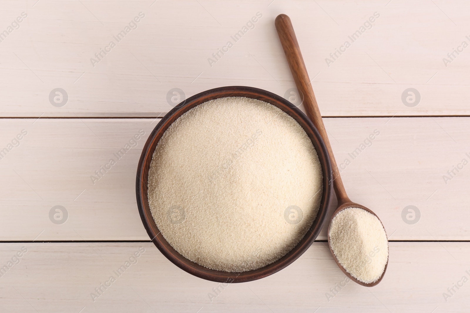 Photo of Uncooked organic semolina on white wooden table, flat lay