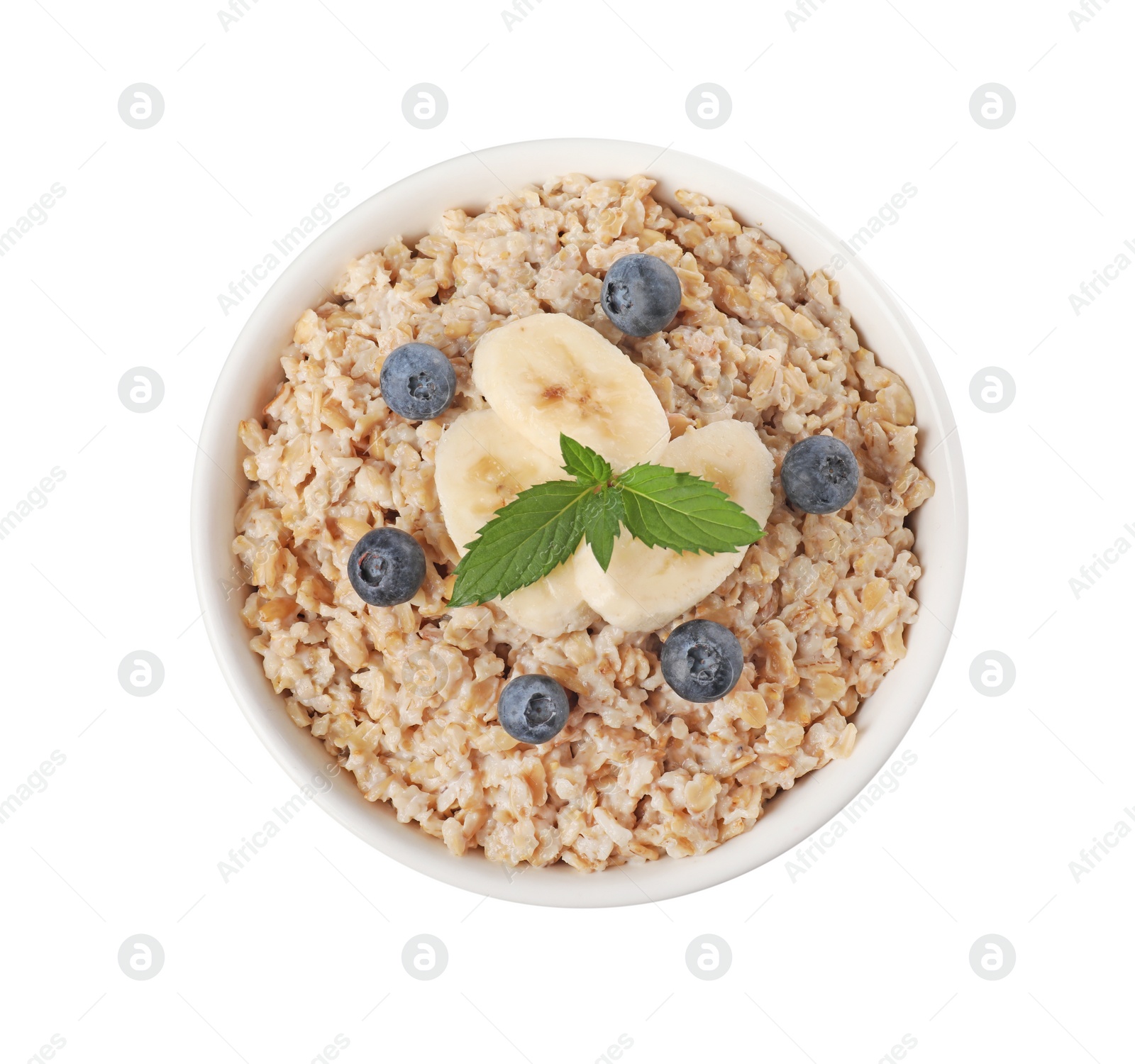 Photo of Tasty boiled oatmeal with blueberries and banana in bowl isolated on white, top view