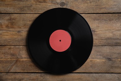 Photo of Vintage vinyl record on wooden background, top view