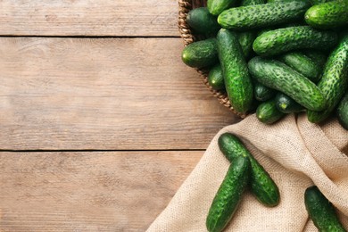 Photo of Fresh ripe cucumbers on wooden background, flat lay. Space for text