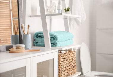 Photo of Fresh towels on decorative ladder in modern bathroom