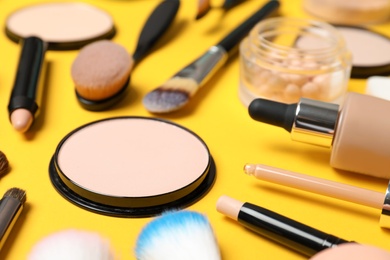 Photo of Composition with skin foundation, powder and beauty accessories on color background