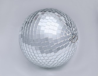 One shiny disco ball on light grey background