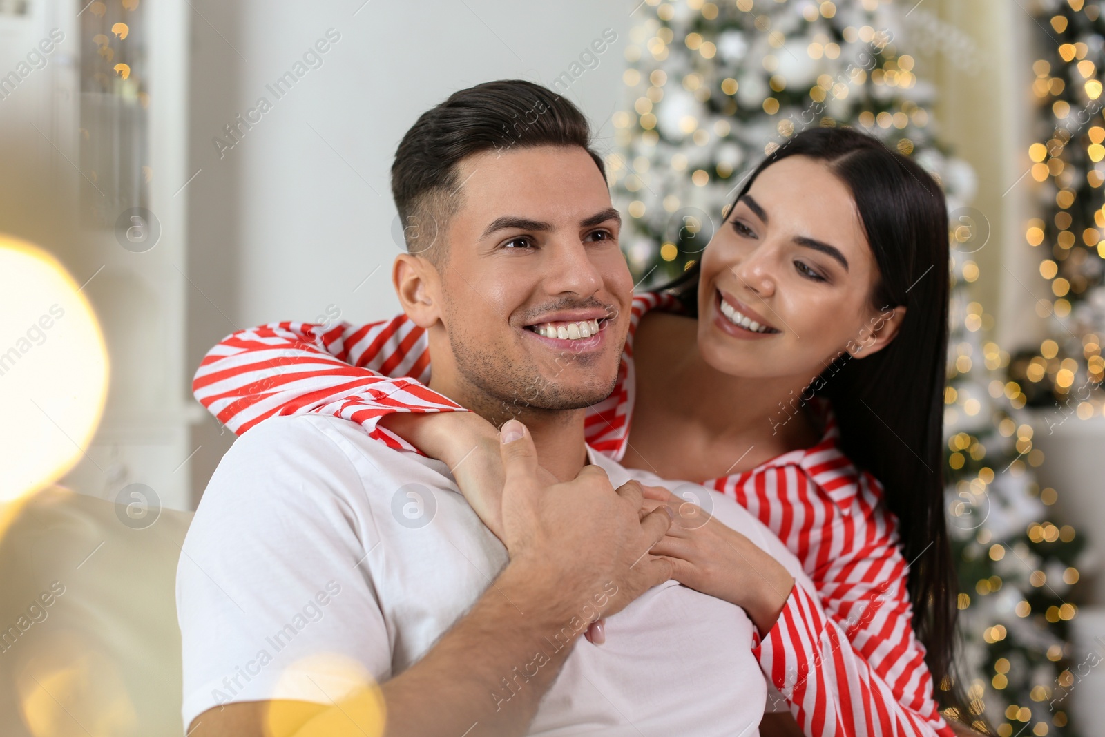 Photo of Happy couple in festively decorated room. Christmas celebration