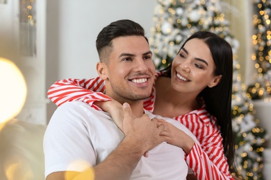 Photo of Happy couple in festively decorated room. Christmas celebration