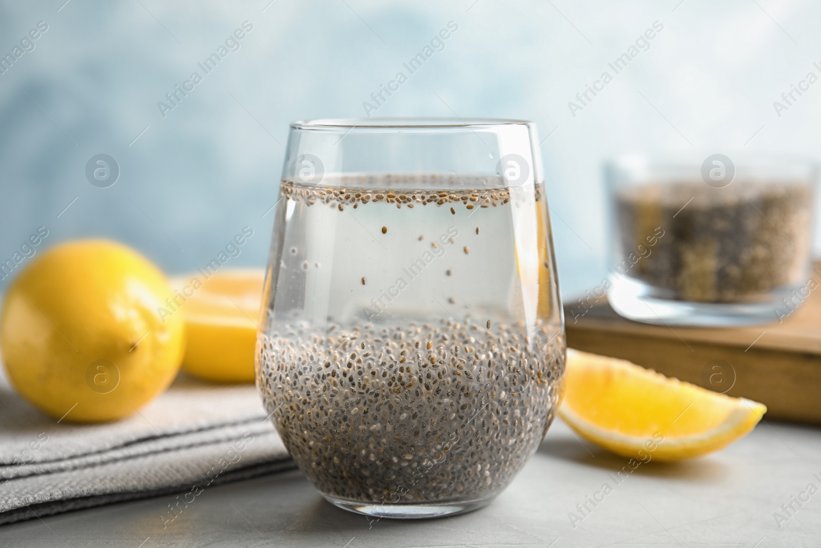 Photo of Composition with glass of water, chia seeds and lemon on table