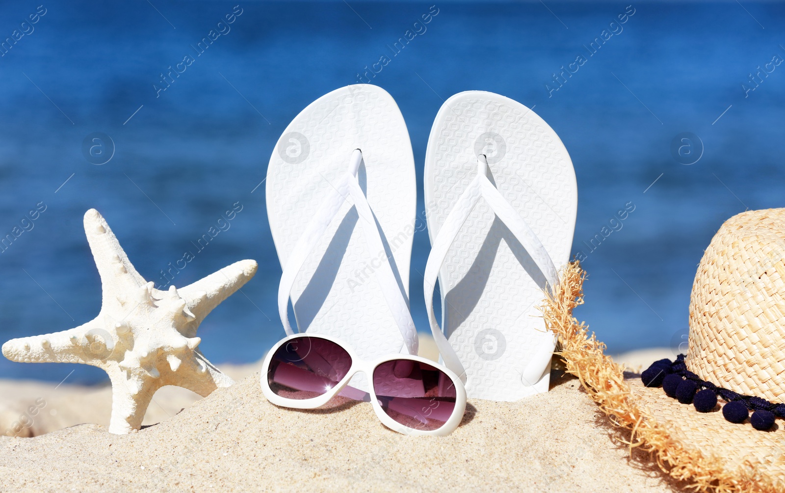 Photo of Composition with beach accessories on sand near sea in summer