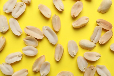 Photo of Fresh peanuts on yellow background, top view