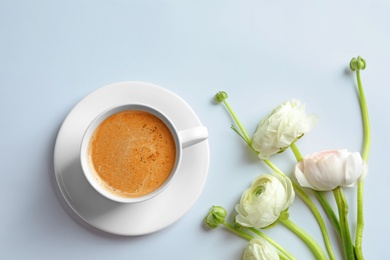 Photo of Cup of hot coffee and beautiful ranunculus flowers on white background