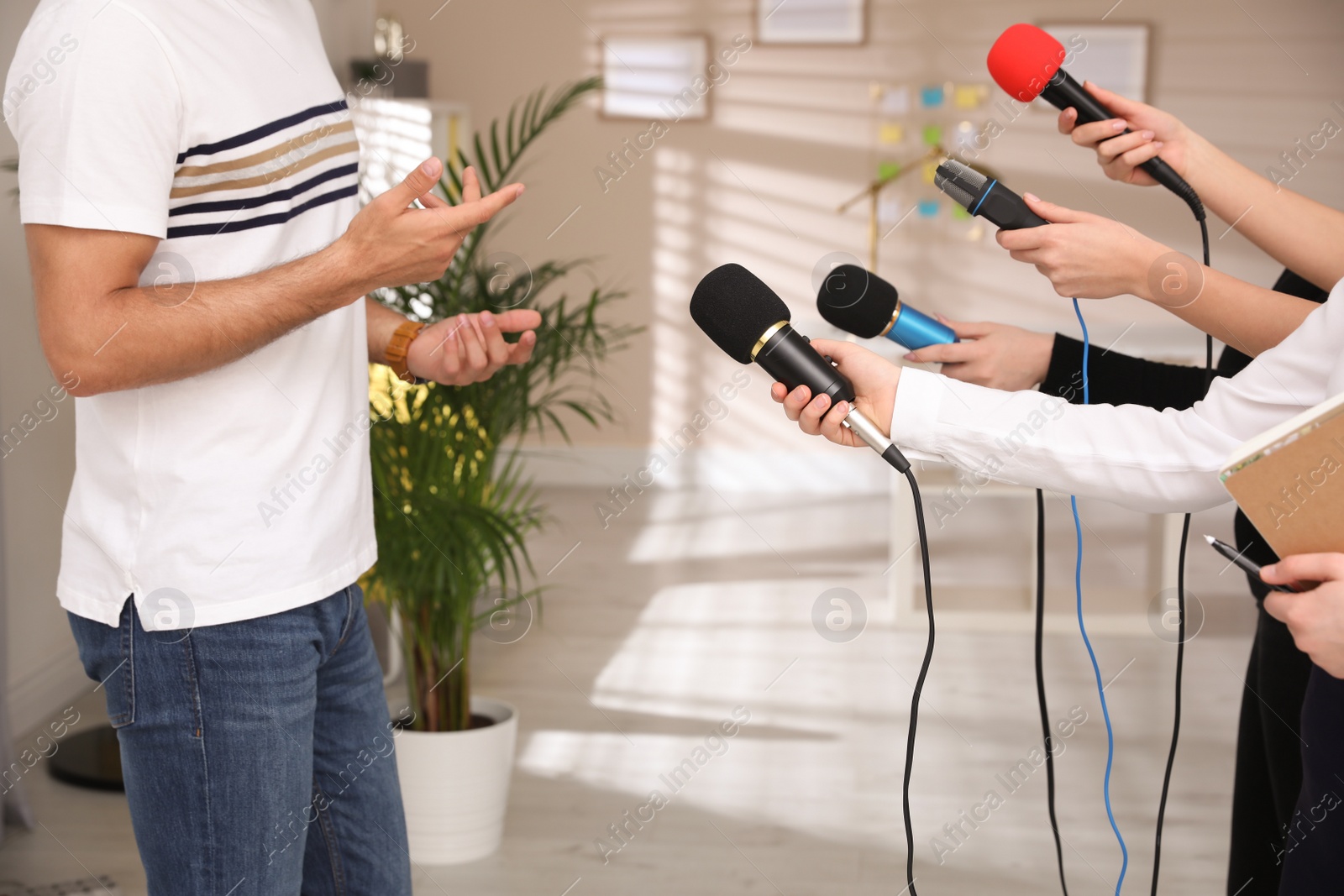 Photo of Group of journalists interviewing man in room, closeup