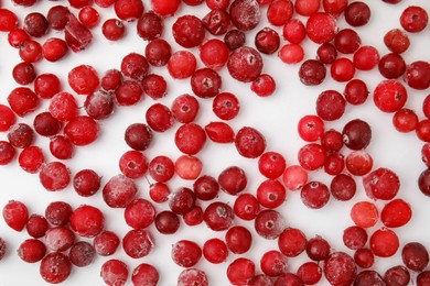 Photo of Frozen red cranberries on white background, flat lay
