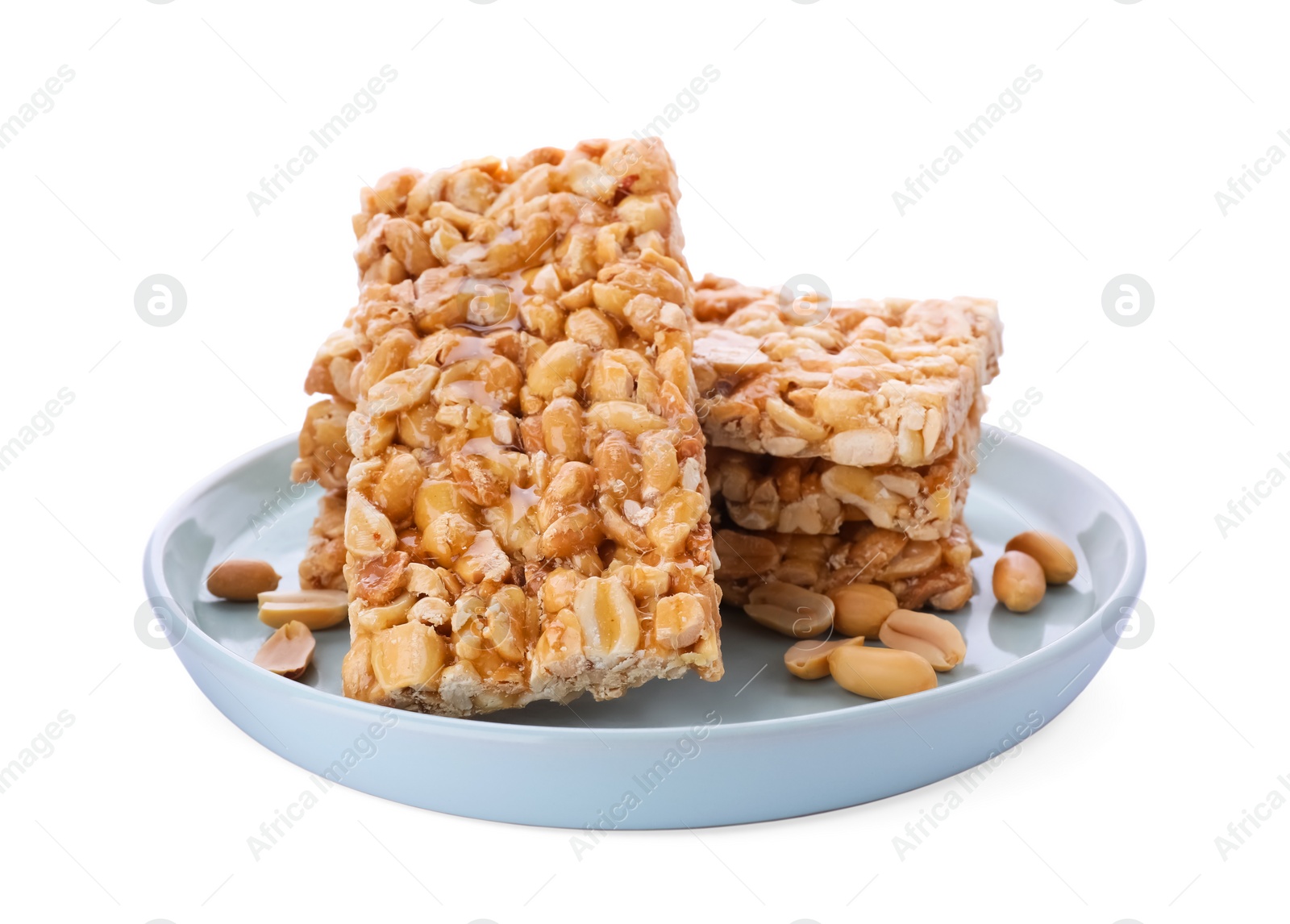 Photo of Plate with tasty kozinaki bars and peanuts isolated on white