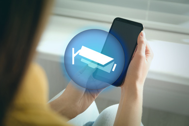 CCTV camera and woman with smartphone indoors, closeup