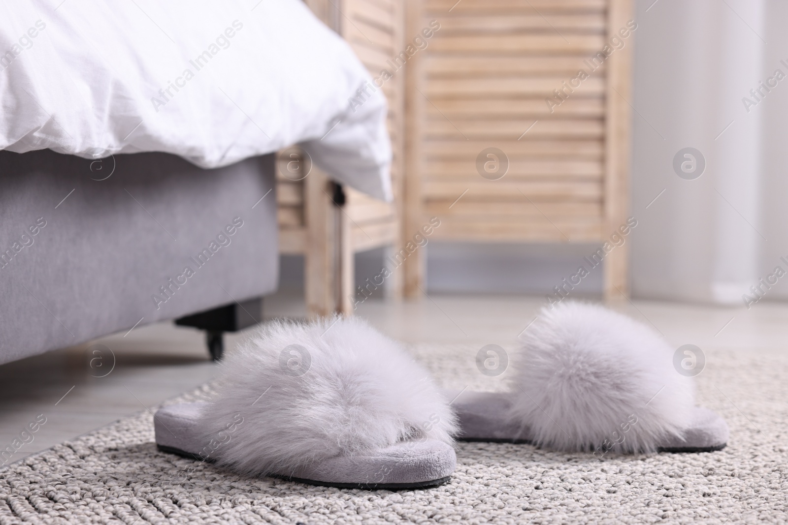 Photo of Grey soft slippers on carpet at home