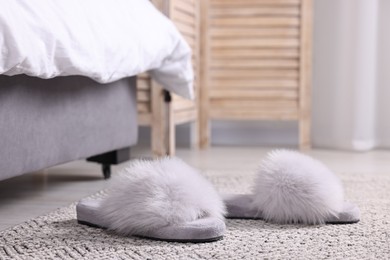 Photo of Grey soft slippers on carpet at home